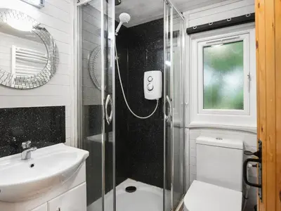 a bathroom with a shower and a toilet and a sink at The Owl's Nest - Uk50546 in Machynlleth