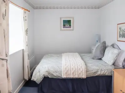 a bedroom with a bed and a window at Cynfal Fawr Farmhouse in Ffestiniog