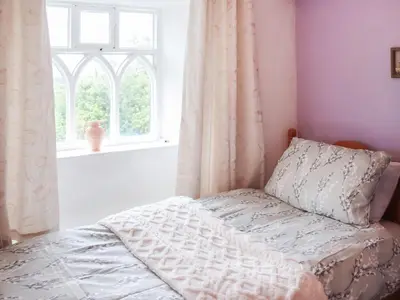 a bedroom with a bed and a window at Cynfal Fawr Farmhouse in Ffestiniog