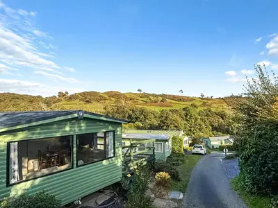 a green tiny house sitting on the side of a road at Hafren View in Machynlleth