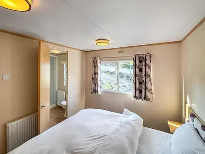 a bedroom with a white bed and a window at Hafren View in Machynlleth