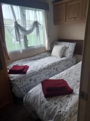 two beds in a small room with a window at Rosie's Rest in Aberaeron