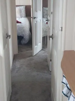 a hallway with two open doors to a bedroom at Rosie's Rest in Aberaeron