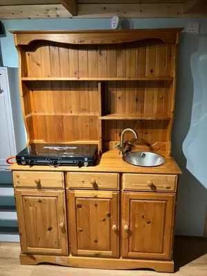 a kitchen with a sink and a wooden cabinet at The Rheidol Shepherds Hut in Aberystwyth