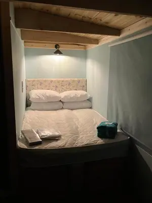 a small bed in a room with two books on it at The Rheidol Shepherds Hut in Aberystwyth