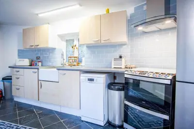 a kitchen with white appliances and blue tiles at West Barn - 2 Bedroom Cottage - Llandeilo in Llandeilo