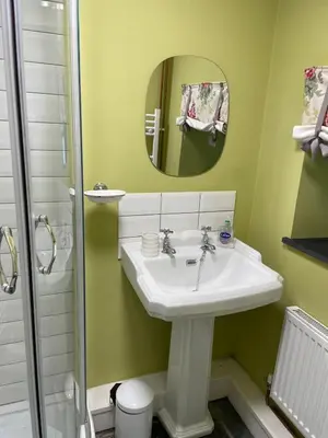 a bathroom with a sink and a mirror at Patchwork cottage - Grade 2 listed cottage in Snowdonia in Maentwrog