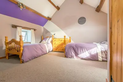 two beds in a attic bedroom with purple ceilings at Cefn-Isaf in Llanbedr