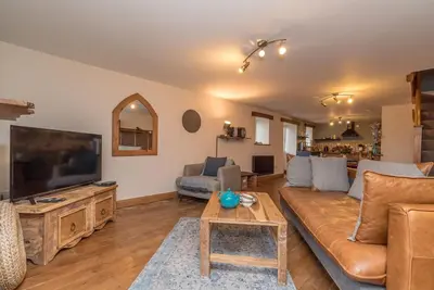 a living room with a couch and a flat screen tv at Cefn-Isaf in Llanbedr