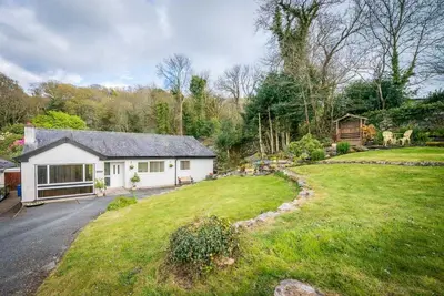 a white house with a yard and a driveway at Mehefin in Harlech