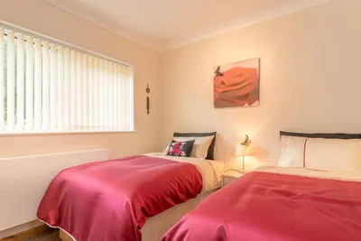 a bedroom with two beds and a window at Mehefin in Harlech