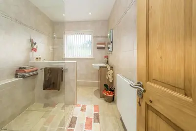 a bathroom with a walk in shower and a door at Mehefin in Harlech