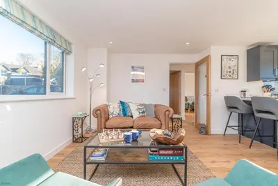 a living room with a couch and a table at Y-Berllan in Dyffryn