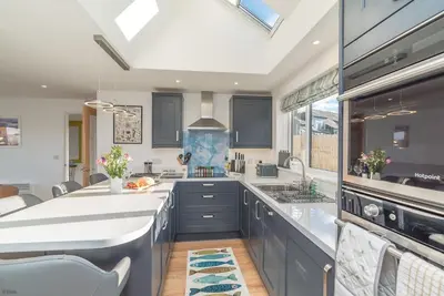 a kitchen with blue cabinets and a large white counter top at Y-Berllan in Dyffryn