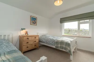 a bedroom with two twin beds and a window at Bryn-Yr-Aur in Llanfair
