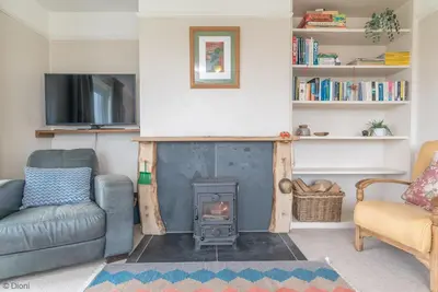 a living room with a fireplace and a couch at Bryn-Yr-Aur in Llanfair