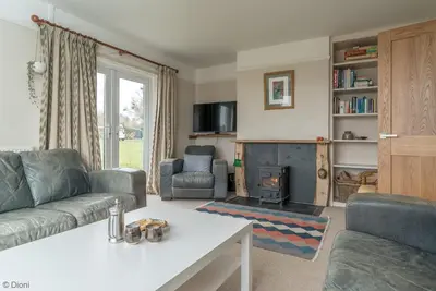 a living room with a couch and a fireplace at Bryn-Yr-Aur in Llanfair