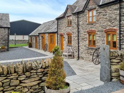 an old stone house with a stone wall at The Dairy -Uk50616 in Corwen