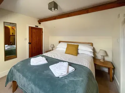 a bedroom with a large bed with towels on it at The Dairy -Uk50616 in Corwen