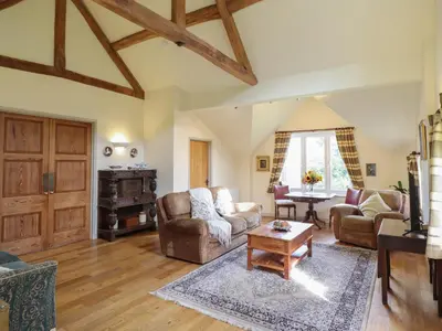 a living room with couches and a table at Upper Pandy Farm in Welshpool