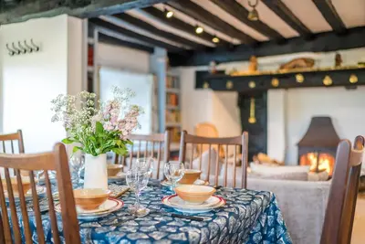a table with a blue table cloth and a vase of flowers at Pwll-Y-March in Llanbedr