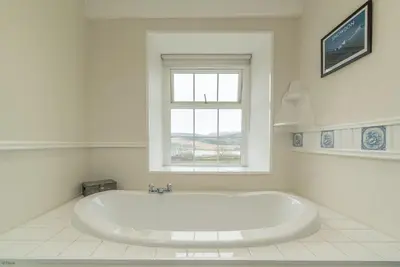 a white bath tub in a bathroom with a window at Rheithordy in Blaenau-Ffestiniog