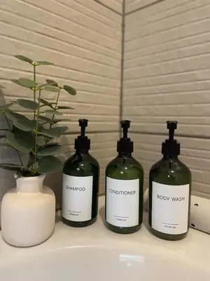 three bottles of wine sitting on a counter with a vase at Vicarage Court detached bungalow in Oswestry