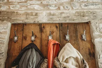 a wooden wall with two coats and hooks on it at Ty Mawr, The Old School Holiday Homes - Pet Friendly in Llanwrtyd Wells
