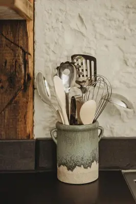 a container filled with utensils sitting on a counter at Ty Mawr, The Old School Holiday Homes - Pet Friendly in Llanwrtyd Wells