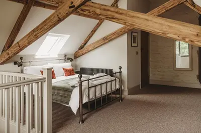 a bedroom with a bed in a room with wooden ceilings at Ty Mawr, The Old School Holiday Homes - Pet Friendly in Llanwrtyd Wells