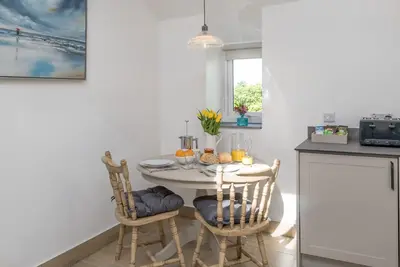 a dining room with a white table and chairs at Stabl-Bennar in Dyffryn