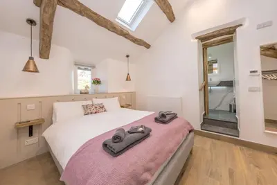 a bedroom with a bed and a mirror at Stabl-Bennar in Dyffryn