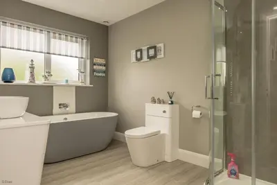 a bathroom with a tub and a toilet and a sink at Tan-Y-Foel in Dyffryn