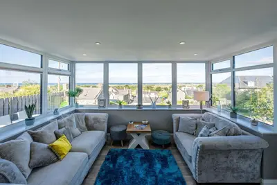 a living room with two couches and large windows at Tan-Y-Foel in Dyffryn