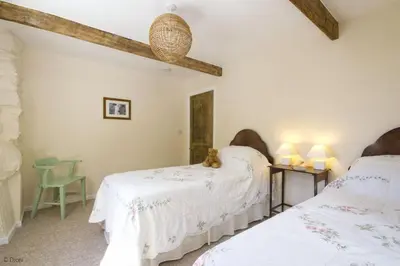 a bedroom with two beds and a table with a teddy bear at Hen-Feudy in Dyffryn