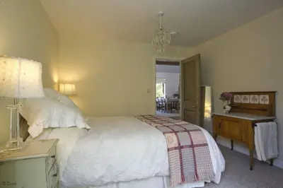 a bedroom with a bed and a table and a lamp at Hen-Feudy in Dyffryn