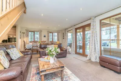 a living room with leather couches and a table at Maes-Artro-Lodge in Llanbedr