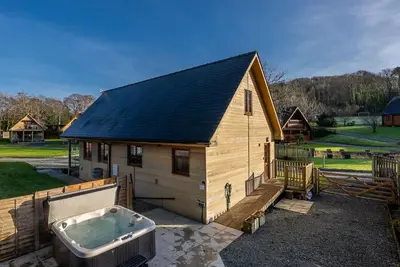 a small house with a bath tub in front of it at Maes-Artro-Lodge in Llanbedr