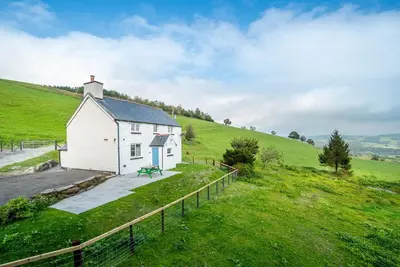 a small white chapel in a green field at Ceseilgwm in Corwen