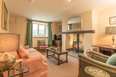 a living room with a couch and a fireplace at Ceseilgwm in Corwen