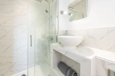 a white bathroom with a sink and a shower at Ysgubor-Bennar in Dyffryn
