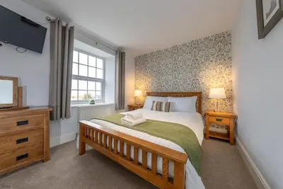 a bedroom with a large bed and a window at Isgoed in Talsarnau