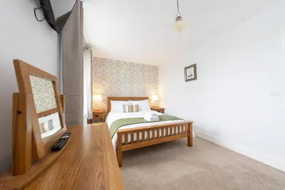 a bedroom with a bed and a wooden table at Isgoed in Talsarnau