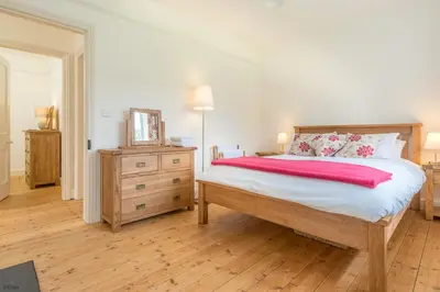 a bedroom with a large bed and a wooden dresser at Maes-Y-Coed in Dolgellau