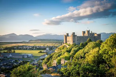 a castle on top of a hill with a town at Allt-Goch in Llanbedr