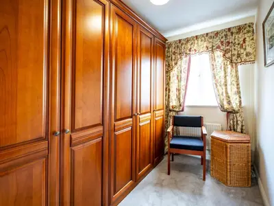 a room with wooden cabinets and a chair and a window at Pass the Keys 3 Bedroom home local to Ludlow town centre in Ludlow