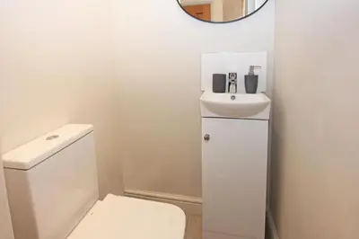 a bathroom with a white toilet and a sink at St John's Hill Apartments in Shrewsbury