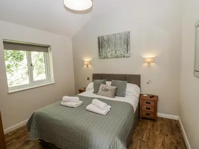 a bedroom with a bed with two towels on it at Dwrgi in Llanybydder