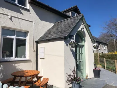 a small house with a table and a picnic table at Calm country cottage in Elerch