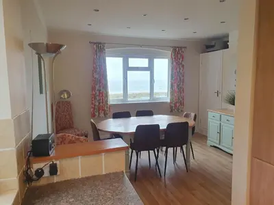 a kitchen and dining room with a table and chairs at High Mead - family house with spectacular views in Aberdyfi